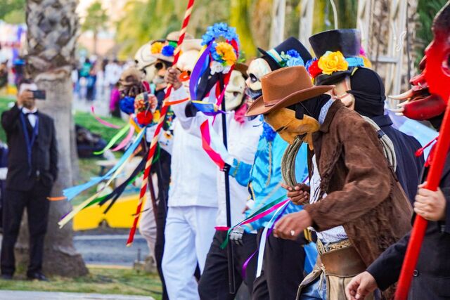 Comparsa de Xantolo con máscaras, sombreros y listones de colores